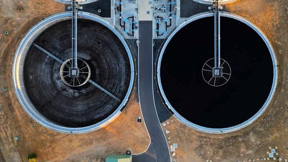 an aerial view of two large black tanks