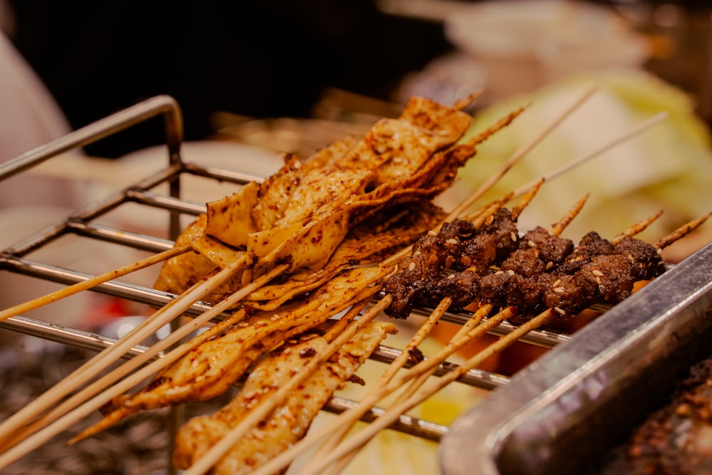 several skewers of food being cooked on a grill