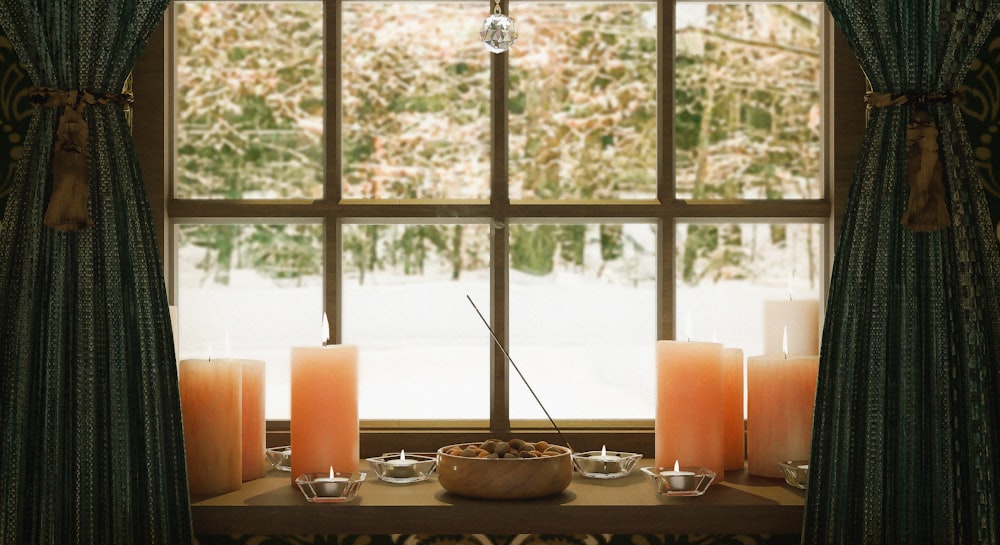 a table with candles and a bowl of fruit on it