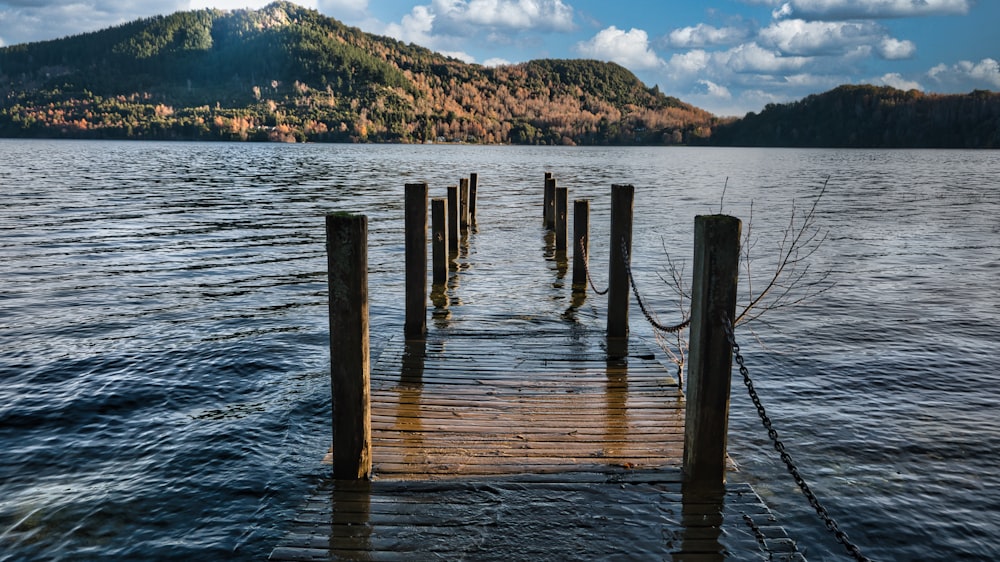 a dock on a lake with a mountain in the background