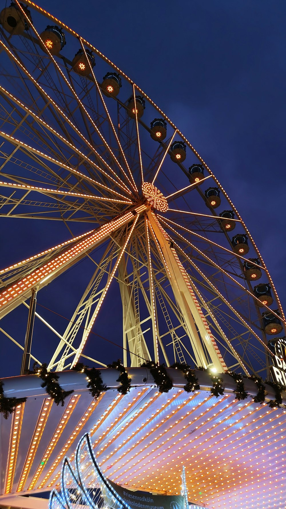 a ferris wheel lit up at night with lights