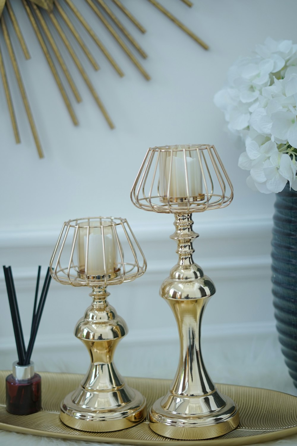 a couple of gold candles sitting on top of a tray