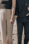 a man and a woman holding hands on the beach