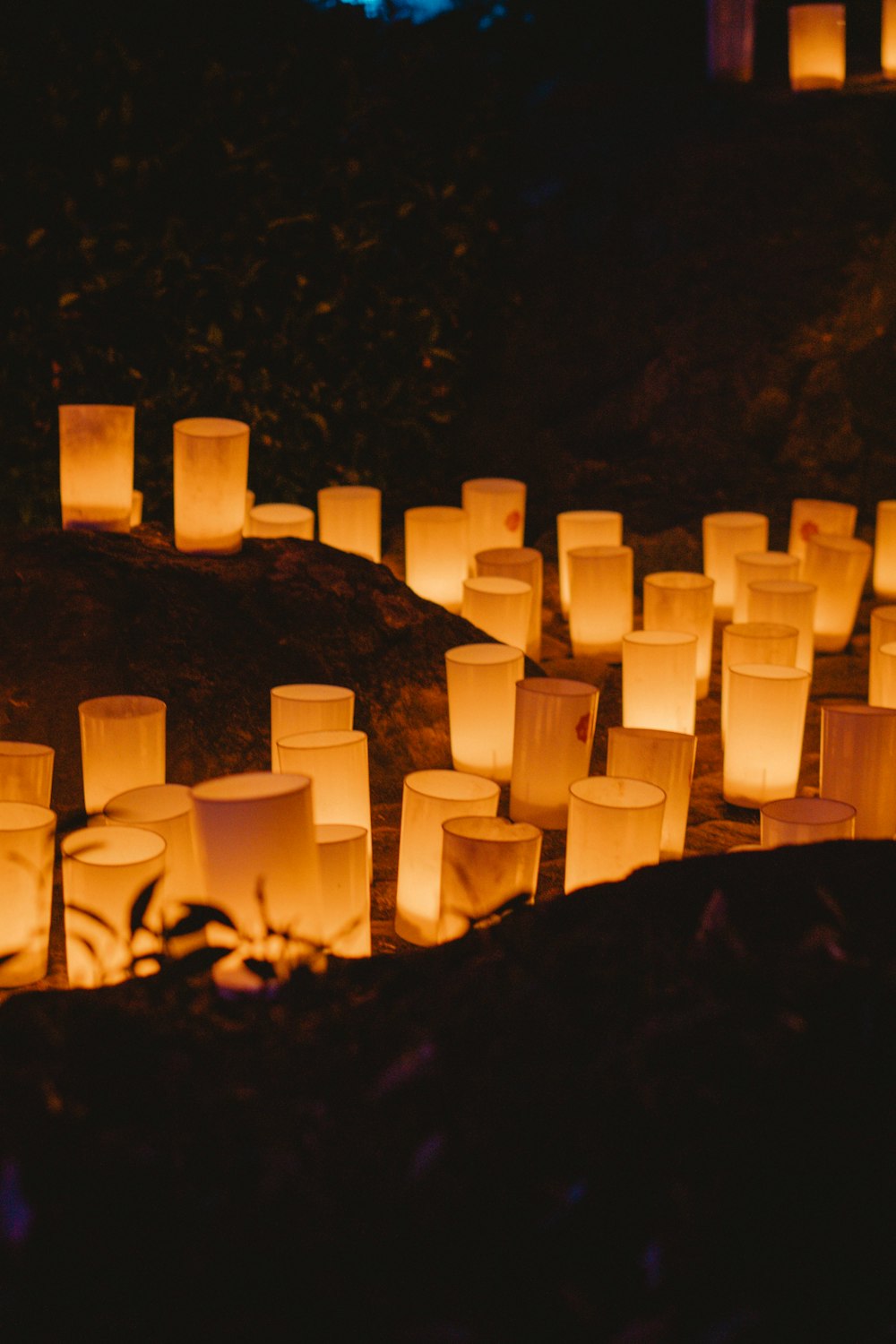 a lot of lit candles sitting on top of a hill