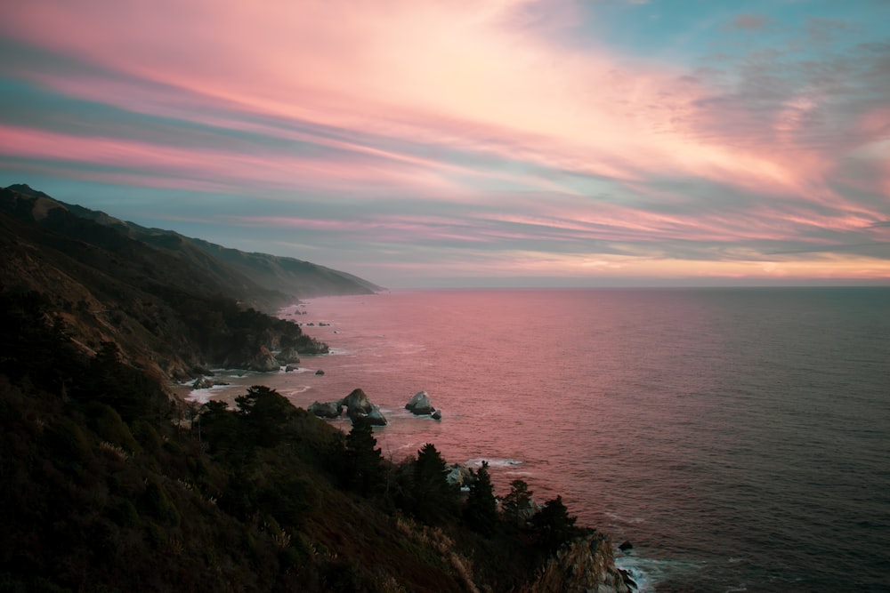 a view of the ocean at sunset from a cliff