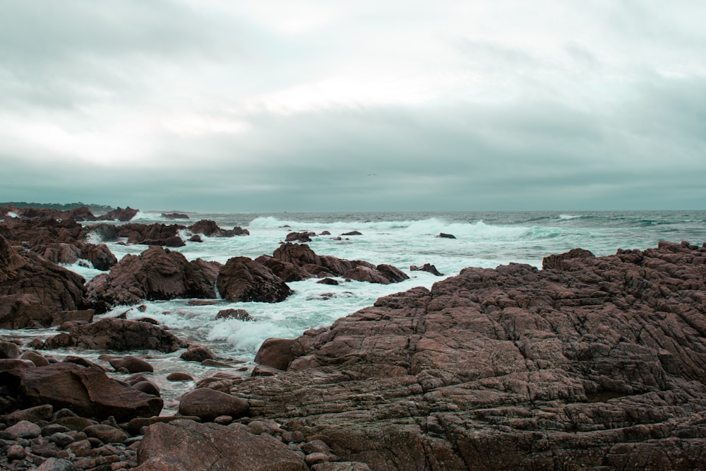 a rocky beach with waves crashing on the rocks