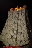 a very tall white building with statues on top of it