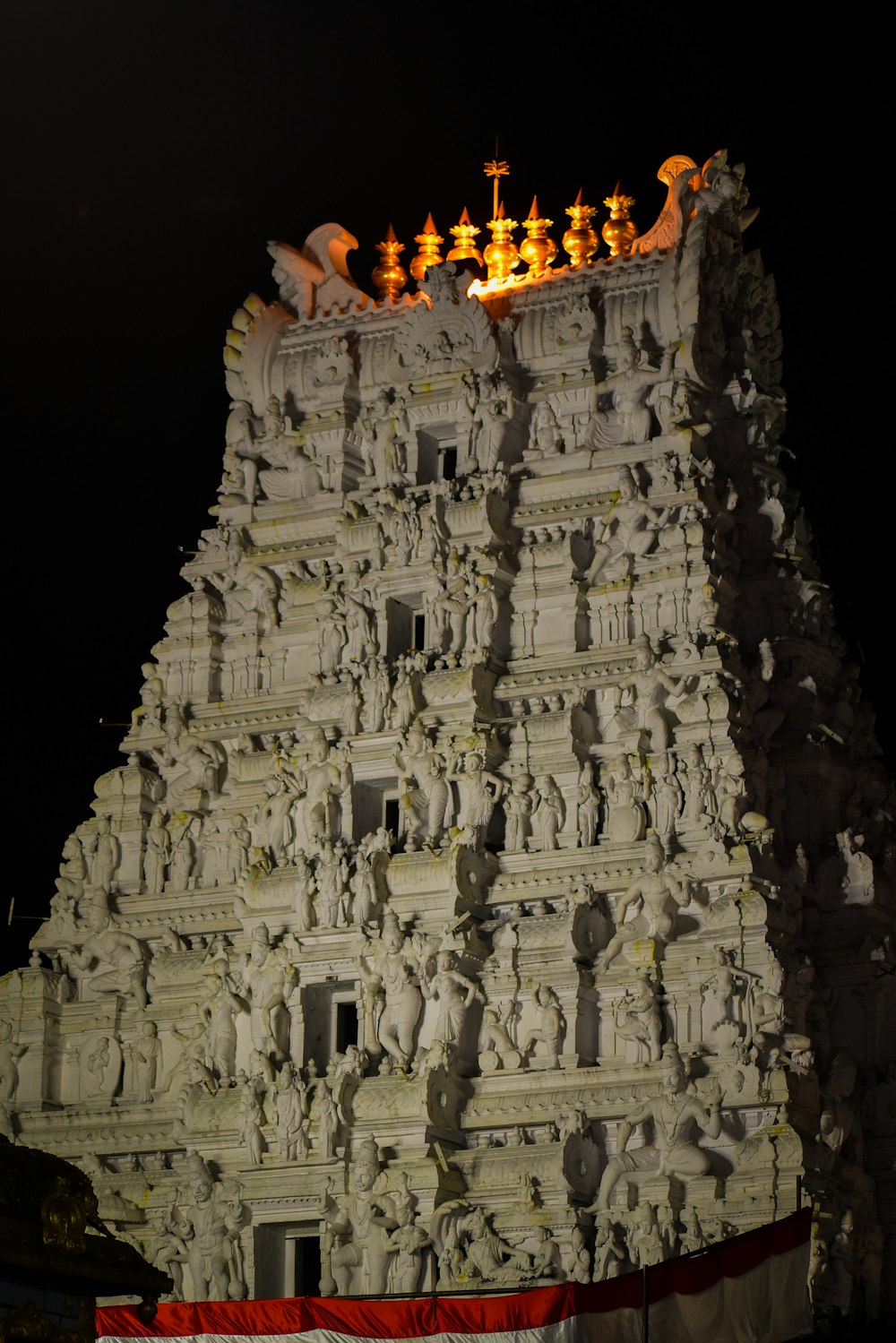 a very tall white building with statues on top of it