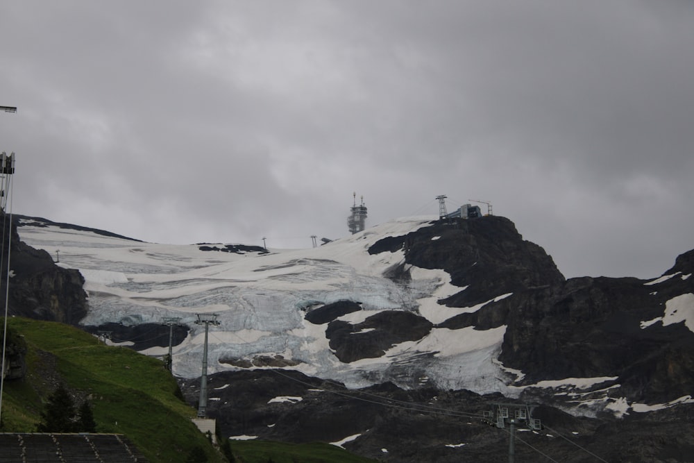 a snow covered mountain with a ski lift in the distance