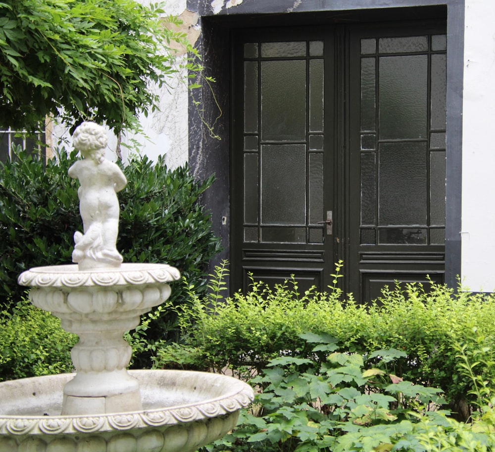 a white fountain in front of a building