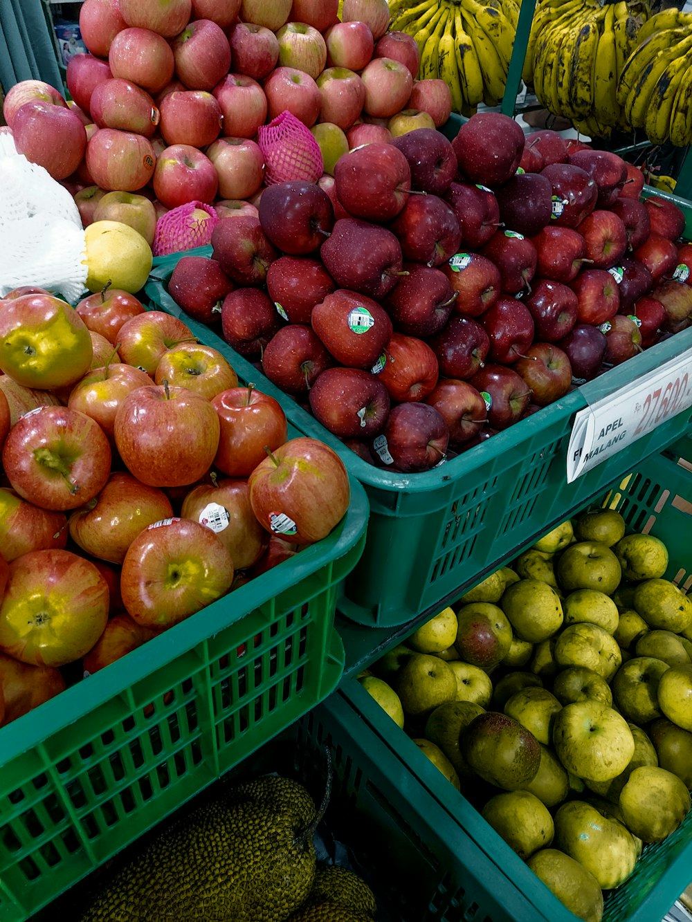 a display of apples, pears, and bananas in baskets