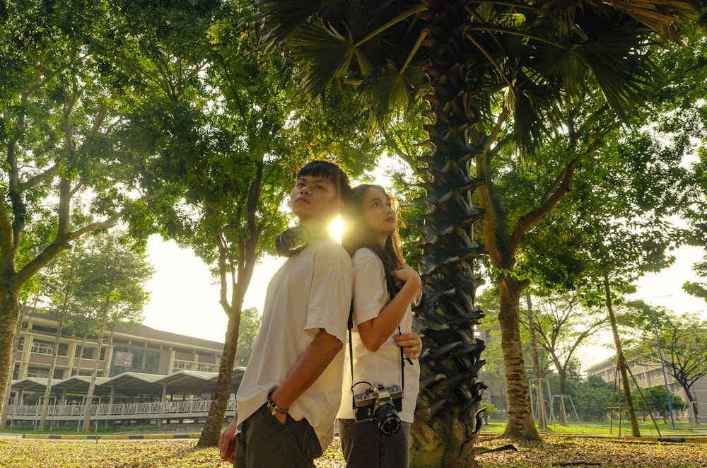 a man and a woman standing under a palm tree