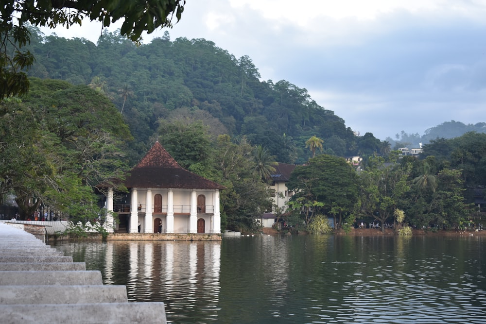 a gazebo in the middle of a lake surrounded by trees