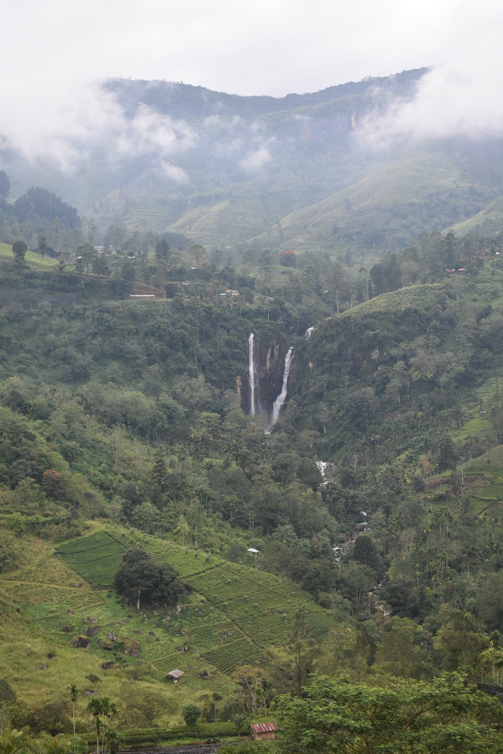 a waterfall in the middle of a lush green valley