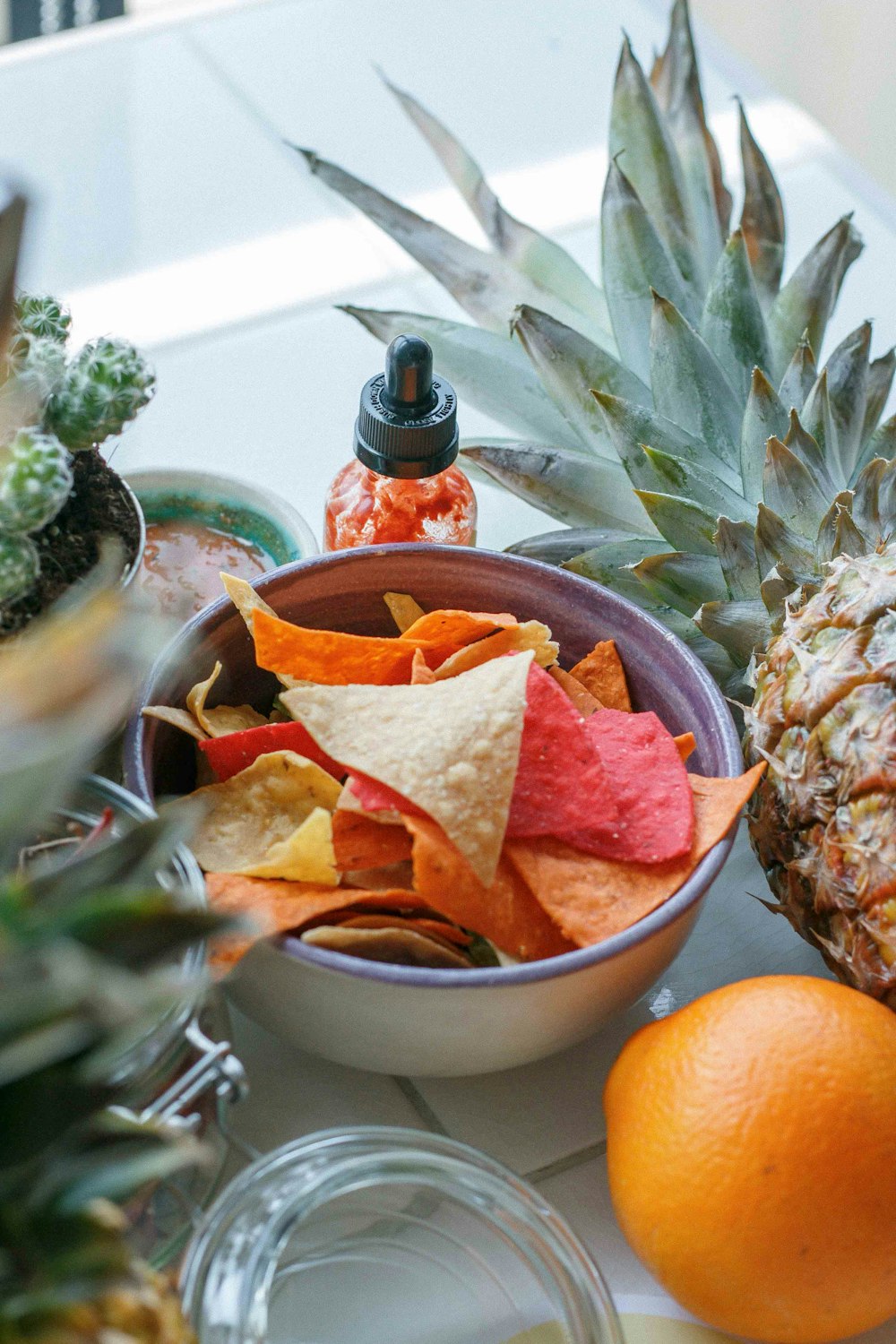 a bowl of chips and a pineapple on a table