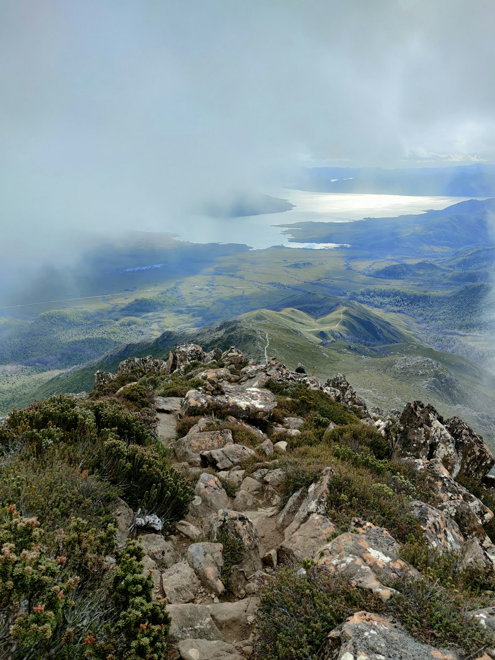 a view from the top of a mountain looking down at a lake