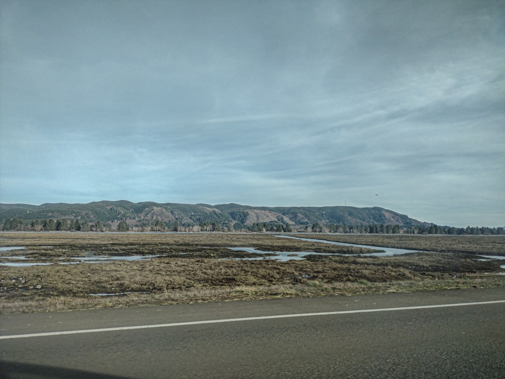 a view from a vehicle of a road and mountains