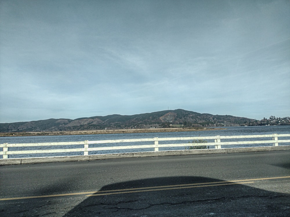 a car driving down a road next to a body of water