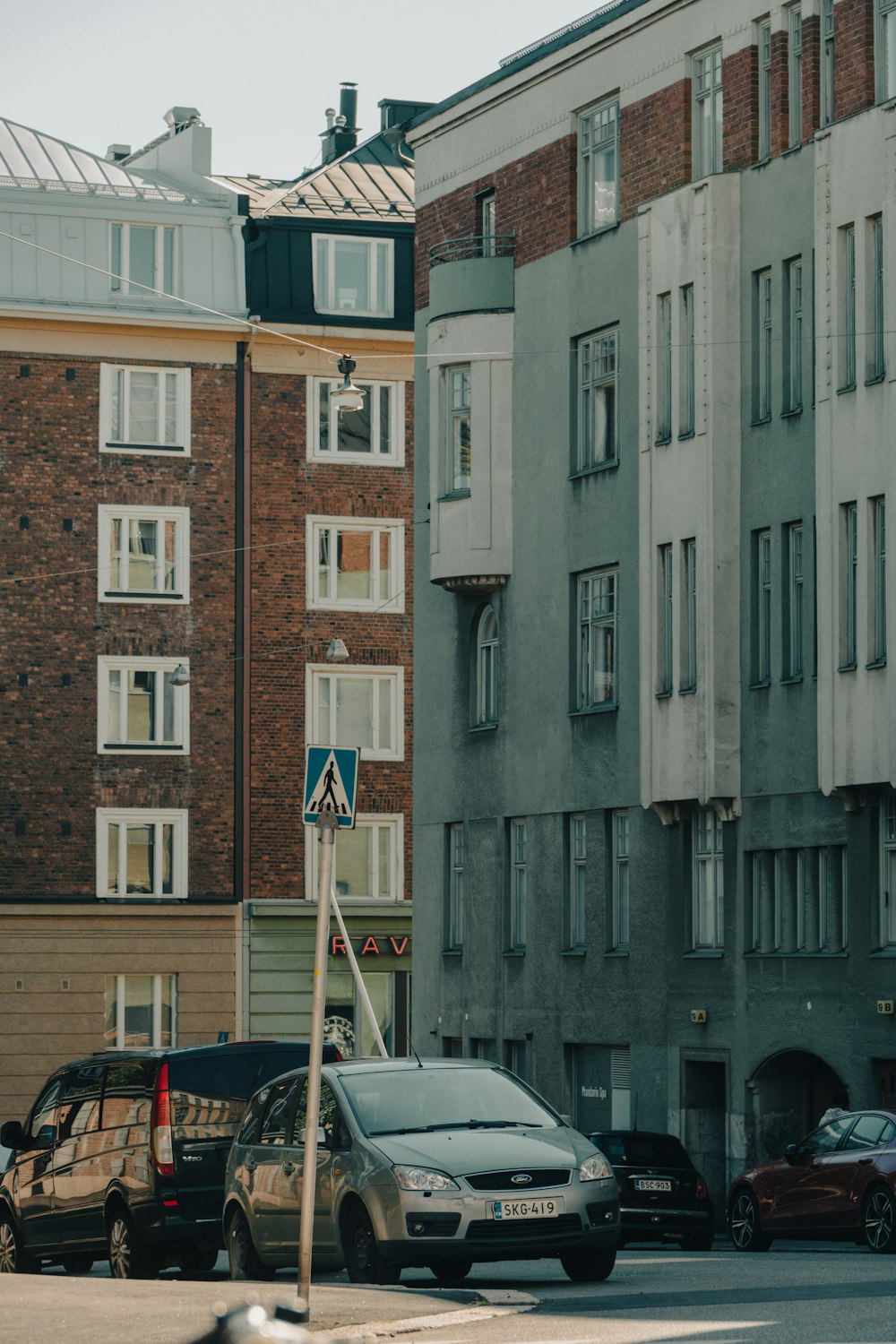 cars parked on the side of the road in front of a building