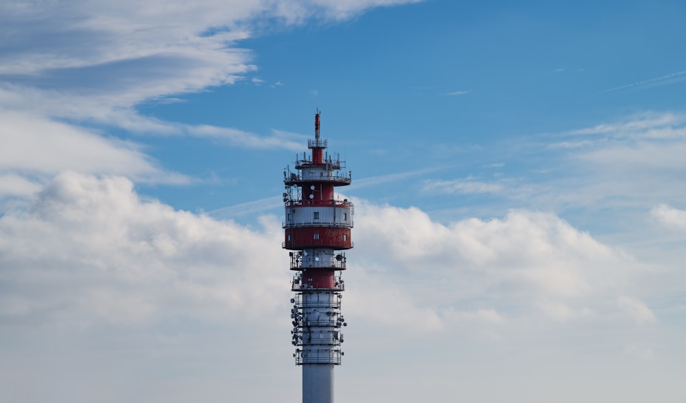 a red and white tower with a sky background