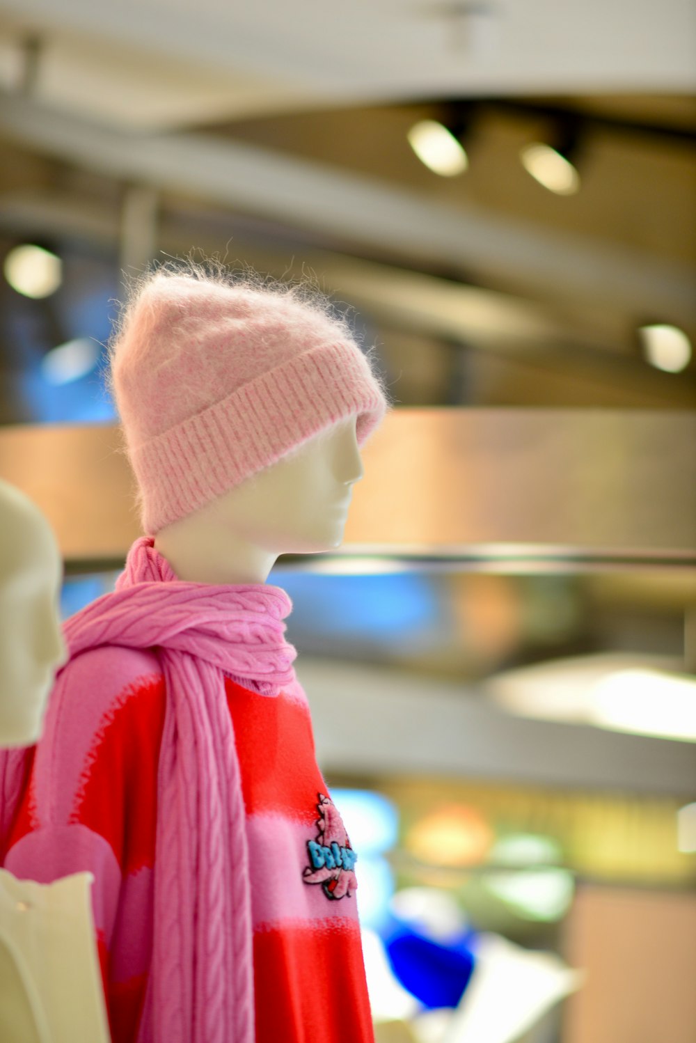 a mannequin wearing a pink hat and scarf