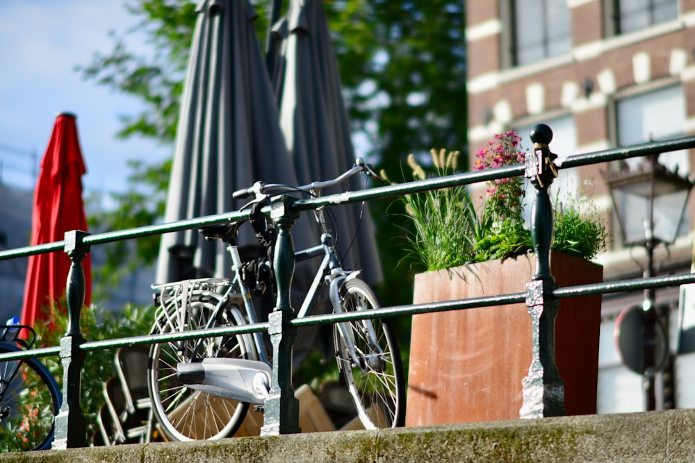 a bicycle is parked on a balcony next to a potted plant