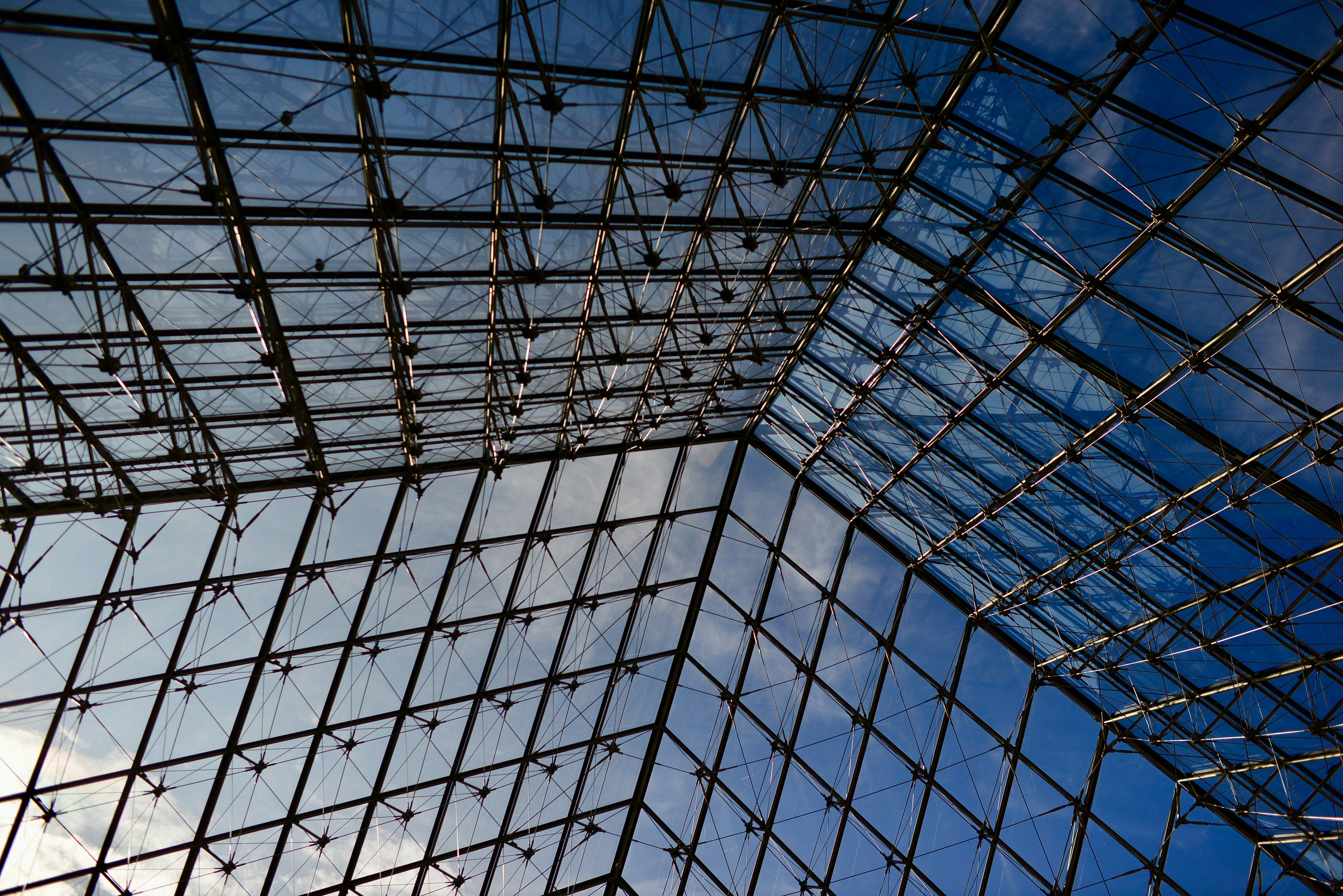 a very tall glass building with a sky in the background