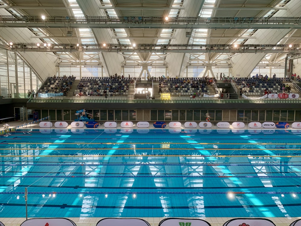 an indoor swimming pool with a large crowd of people