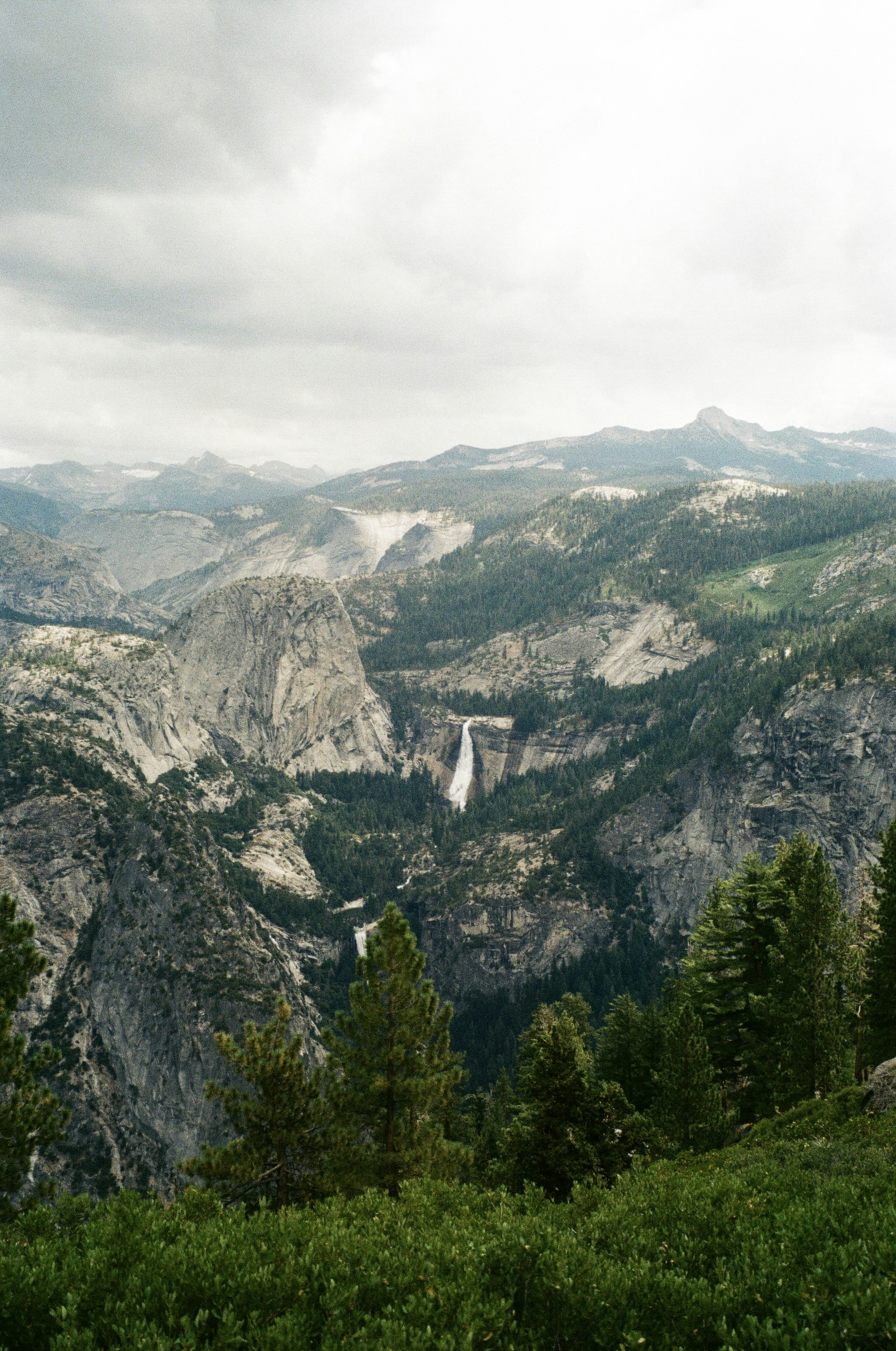 a view of a mountain range with a waterfall in the distance