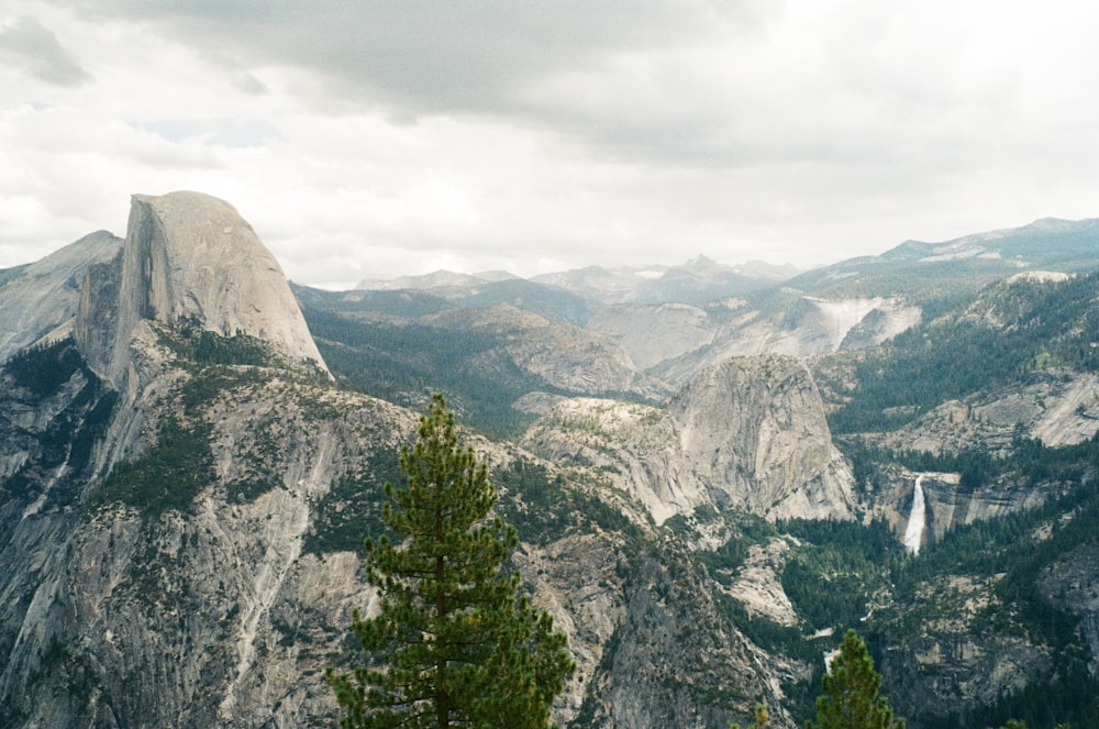 a view of a mountain range with a waterfall in the distance