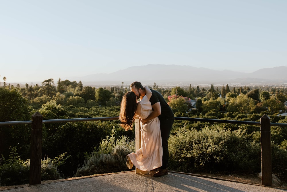 a man and a woman kissing on a balcony