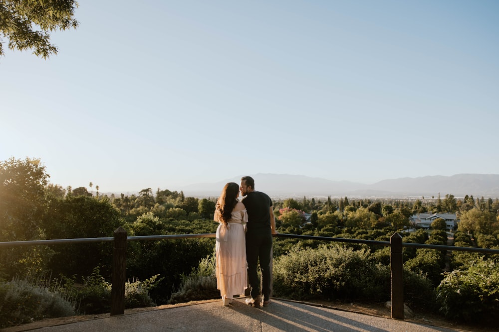 a man and a woman standing on top of a hill