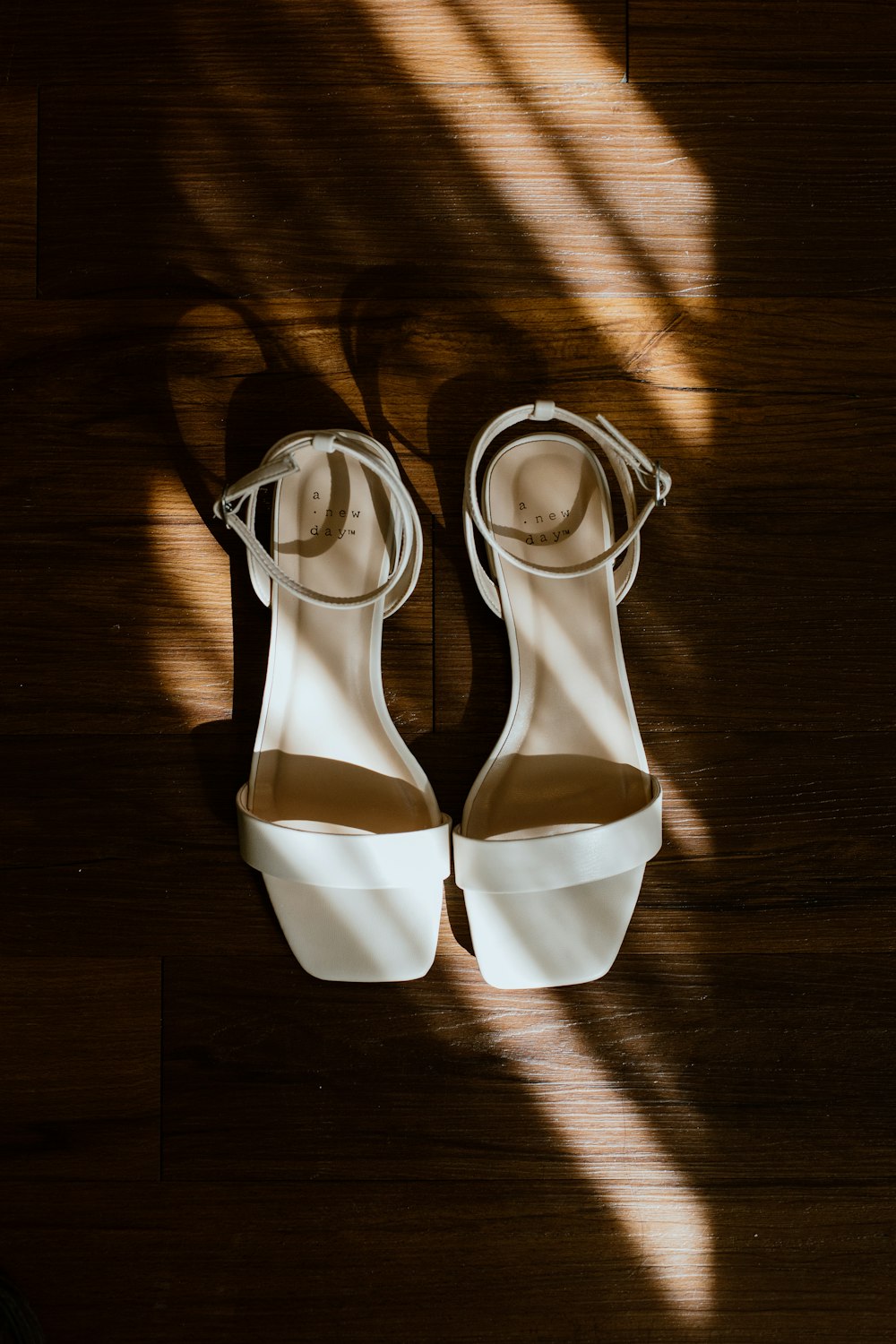 a pair of white shoes sitting on top of a wooden floor