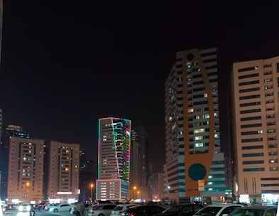 a parking lot filled with lots of cars next to tall buildings