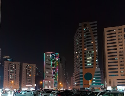 a parking lot filled with lots of cars next to tall buildings