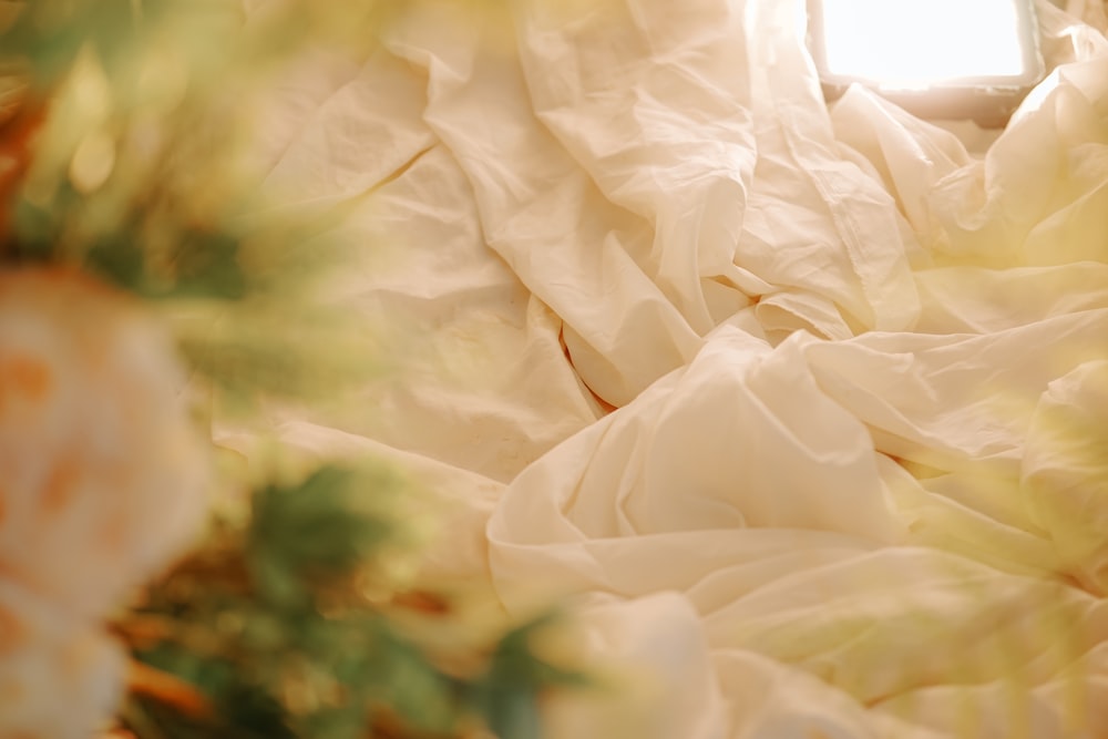 a close up of a bed with white sheets