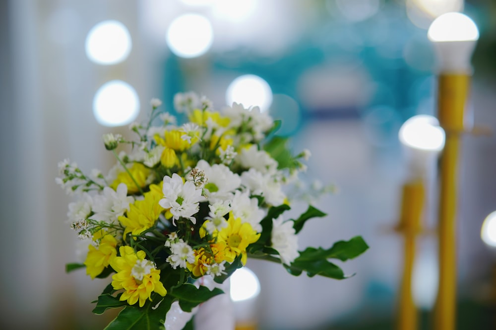 a vase filled with yellow and white flowers