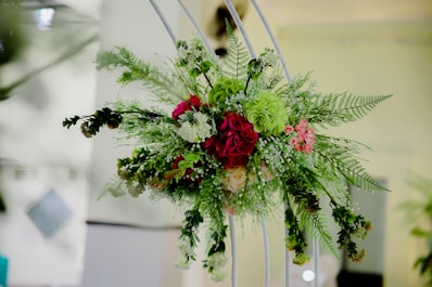 a bouquet of flowers hanging from a metal frame