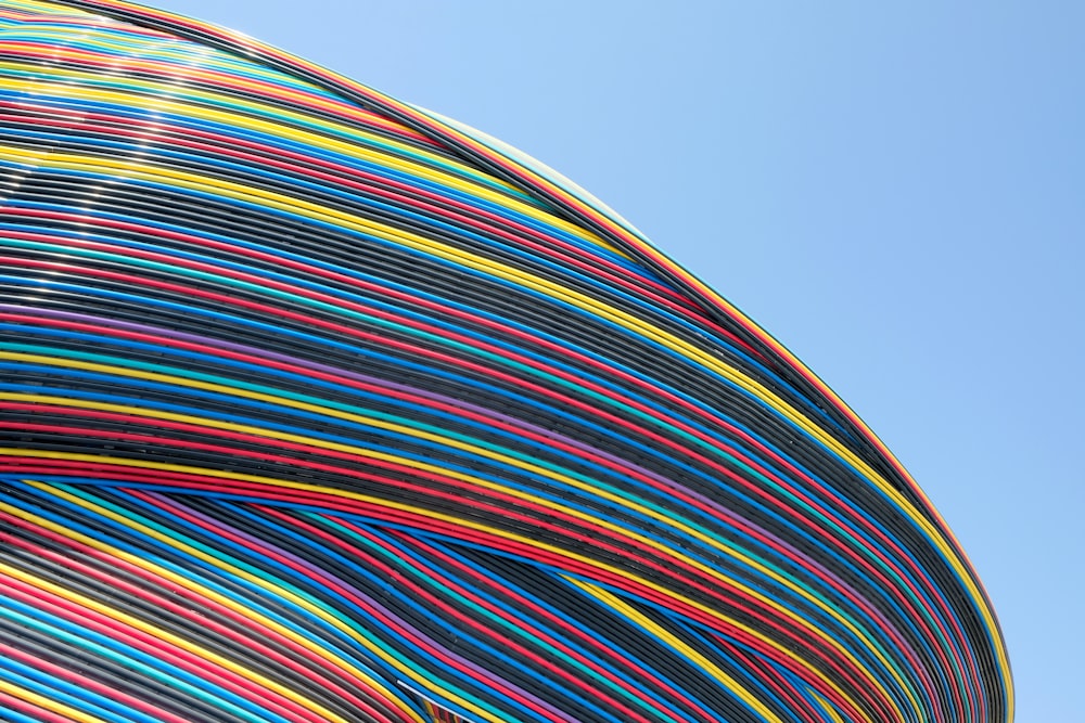 a large multicolored object with a blue sky in the background