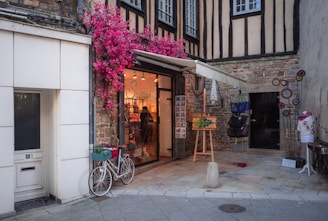 a bike parked outside of a building with flowers on it