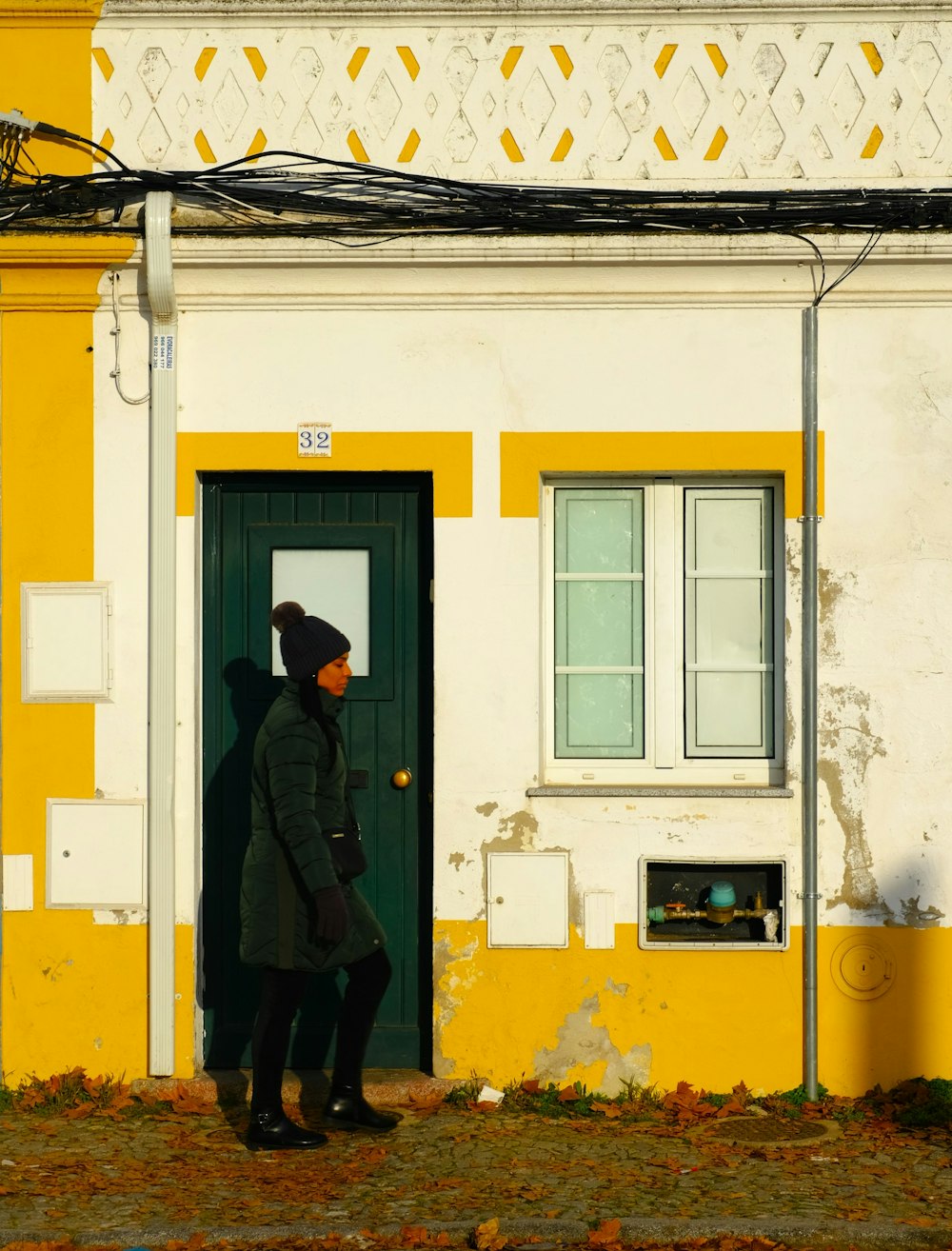 a woman standing in front of a yellow and white building