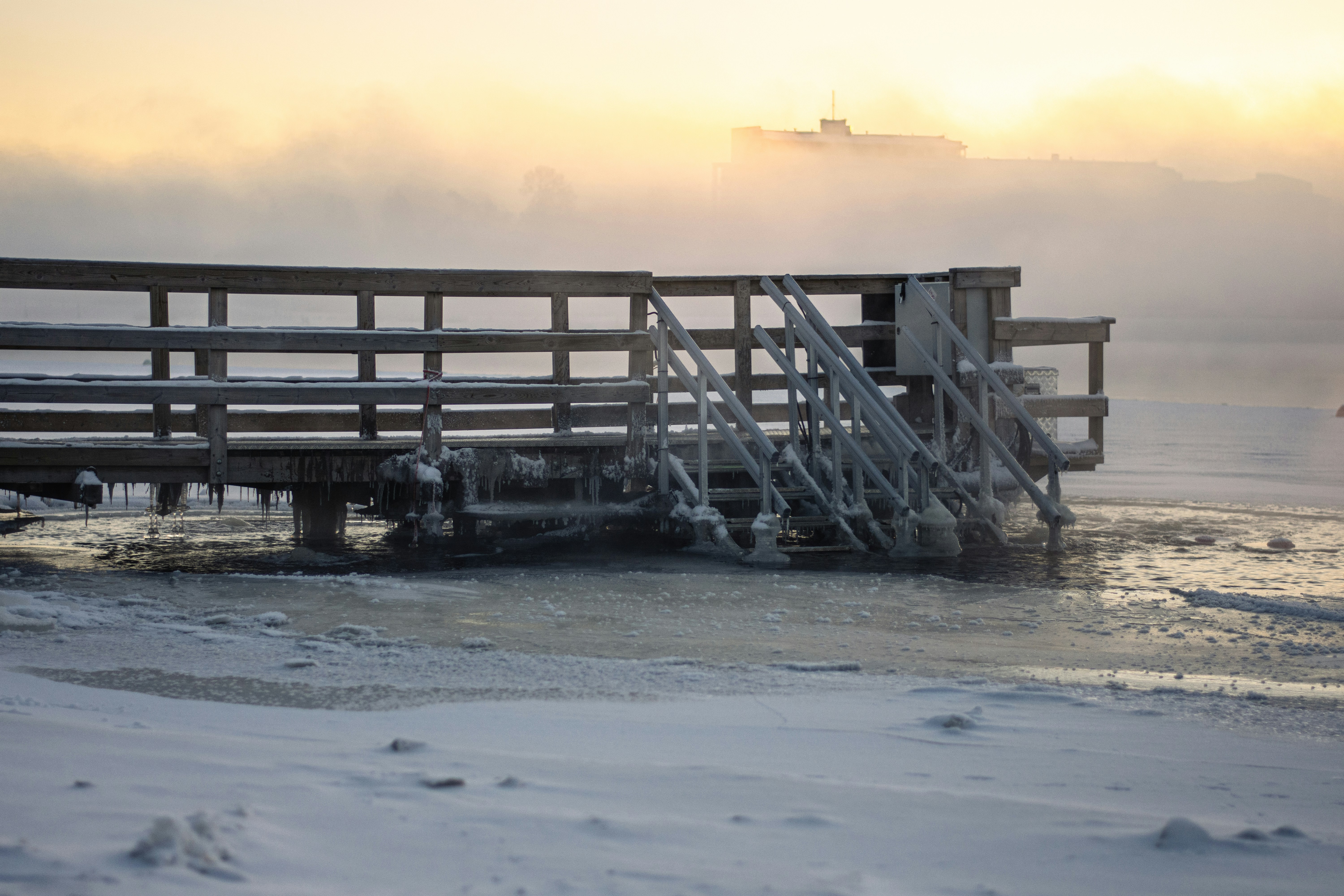 a wooden dock with a boat in the background, 