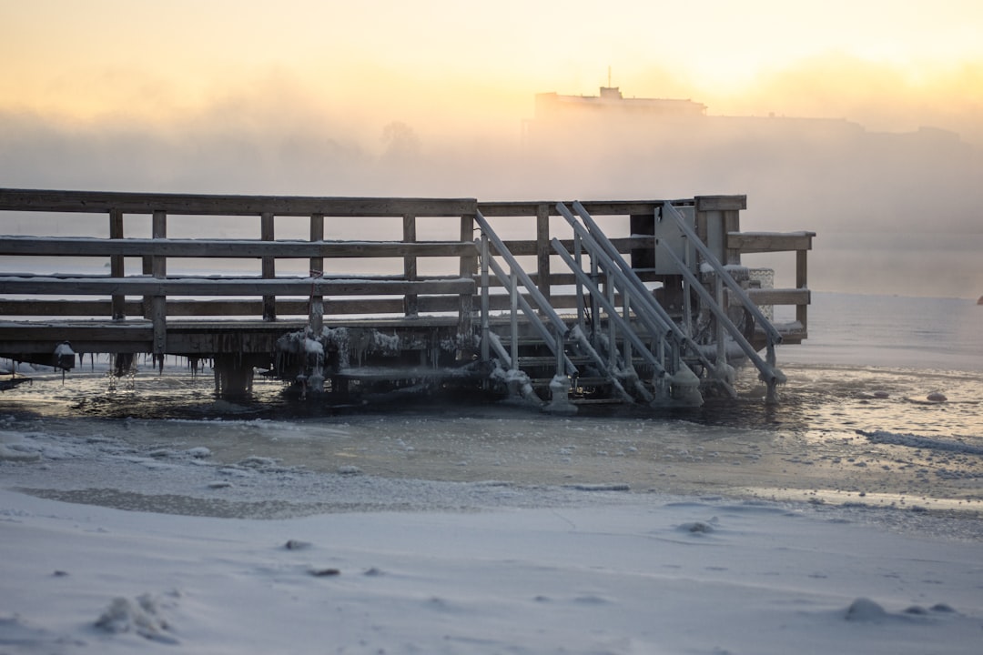 a wooden dock with a boat in the background,