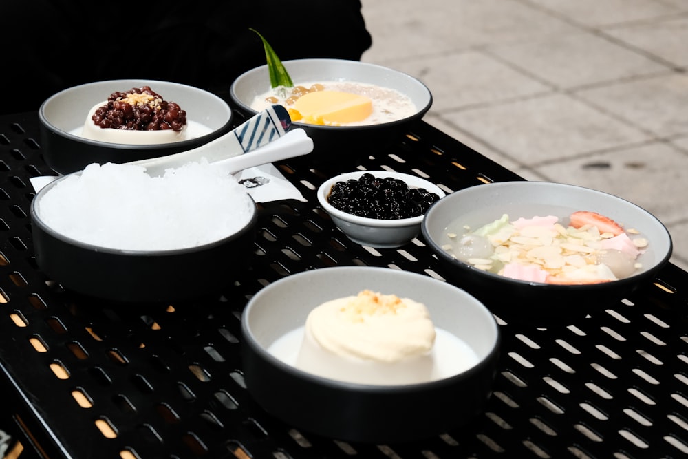 a black table topped with bowls of food