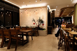 a restaurant with tables, chairs, and plants
