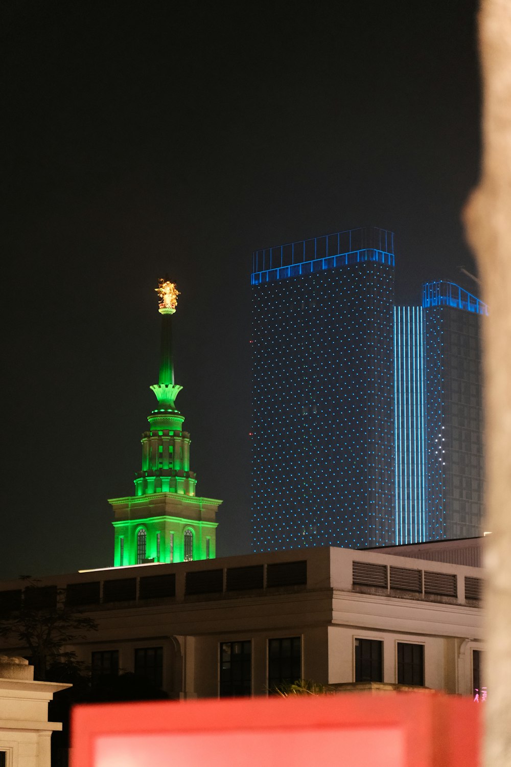 a tall building with a clock tower lit up at night