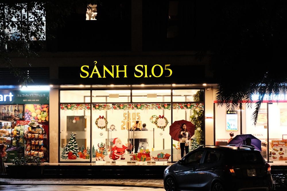 a car parked in front of a store at night