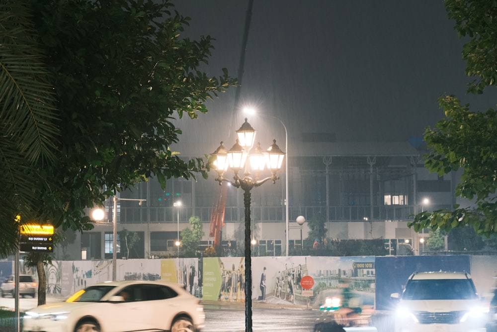 a white car driving down a street at night