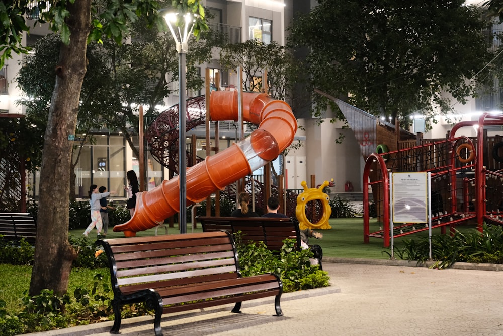 a playground with a slide and a wooden bench