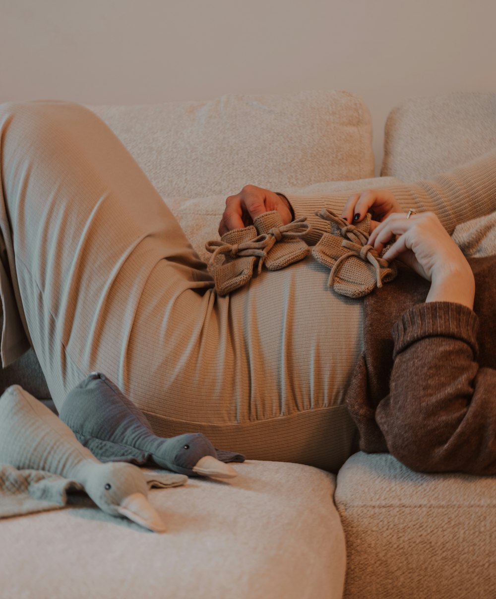 a person laying on a couch with a stuffed animal